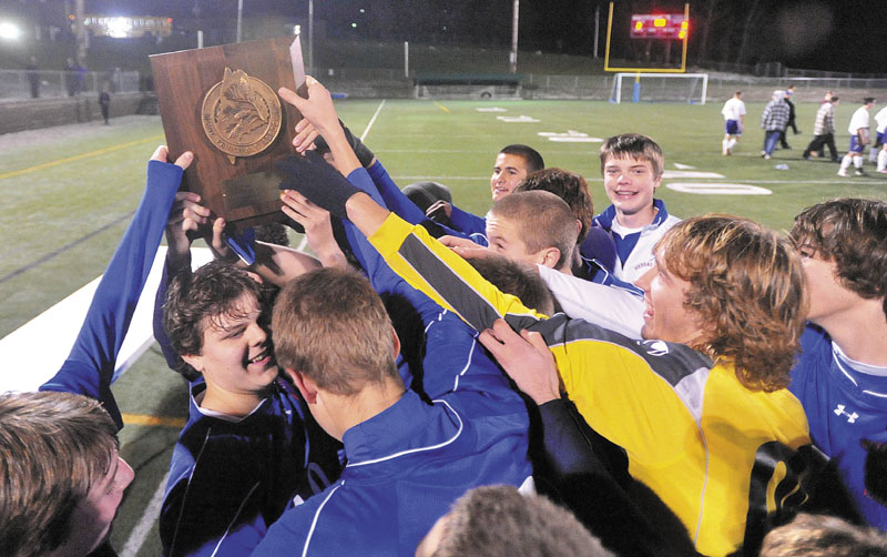 The Messalonskee High Scool boys soccer team hoist the CLass A championship trophy after defeating Hampden Academy 3-2 n the Class A boys Eastern Maine Championship game at Hampden Academy Wednesday.