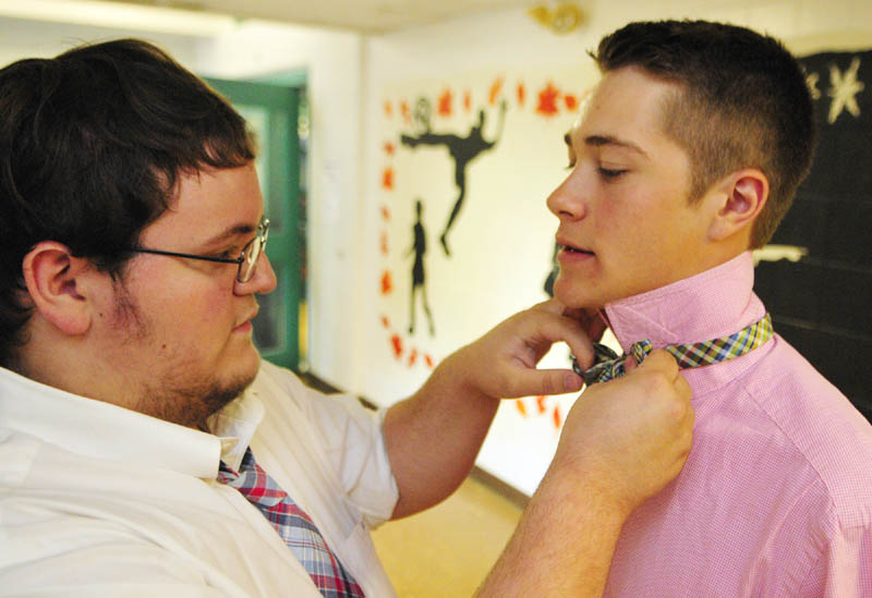 Morgan Hisler, left, helps fellow senior Kurt Thiele with his bow tie as they get ready before the Hall-Dale High School commencement ceremony on Saturday at the school in Farmingdale.