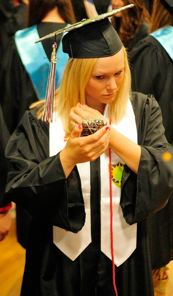 Wearing a white Maine National Guard sash, Courtney Pierce checks her reflection on the screen of her phone before the Hall-Dale High School commencement ceremony on Saturday at the school in Farmingdale. Pierce, 19 of Farmingdale, said that she plans to be a mechanic with the guard.