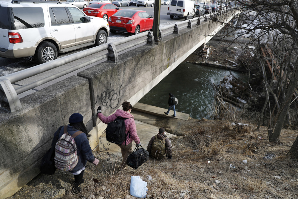 Medical assistant Lina Marin, from left, registered nurse Laura Lacroix, physician assistant Brett Feldman and community outreach specialist Bob Rapp visit a homeless camp under a bridge in Allentown, Pa. Street medicine got its start more than 30 years ago as an altruistic pursuit of individual doctors and nurses. In cities scattered around the country and the world, they left the office and headed outside to care for the chronically homeless, a population that is generally sicker and dies far younger than people with homes.