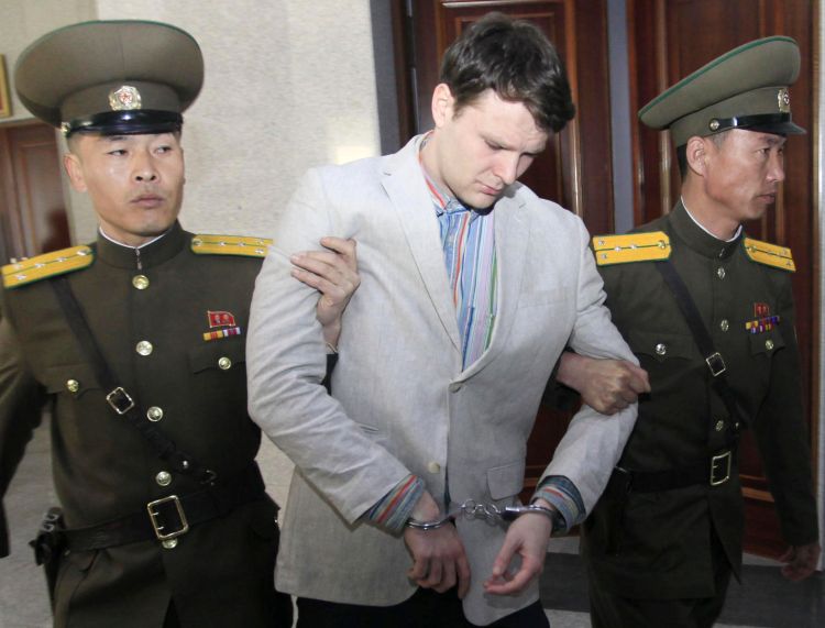 Otto Warmbier is escorted by North Korean guards at the Supreme Court in Pyongyang Wednesday. He allegedly attempted to steal a propaganda banner from his hotel. The Associated Press