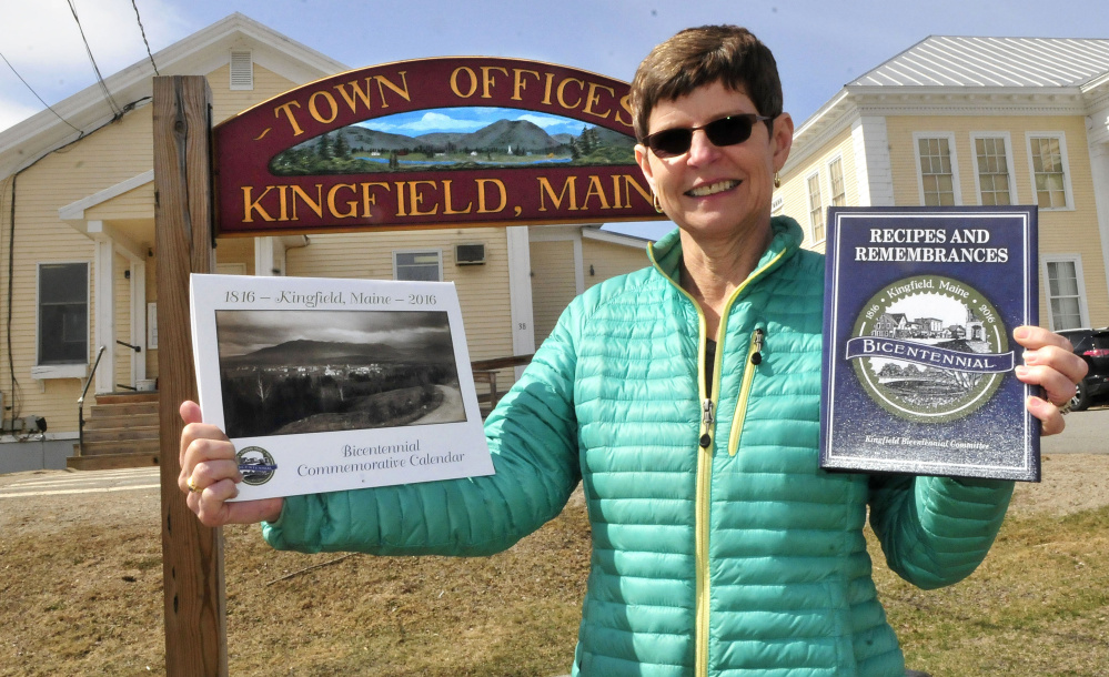 Tammy Goldfrank, chairwoman of the Kingfield Bicentennial Committee, holds copies of the town bicentennial calendar and cookbook Wednesday in front of the Kingfield Town Office. Many bicentennial events are scheduled for this weekend.