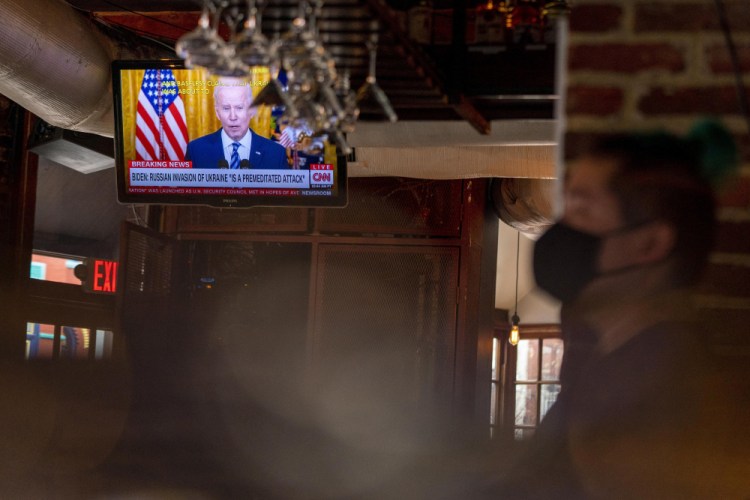 President Biden speaks about Russia's invasion of Ukraine on a television at Shaws Tavern in Washington on Thursday. He will deliver his State of the Union address to a joint session of Congress on Tuesday. 