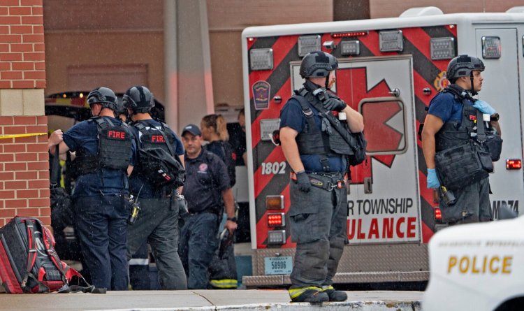 Law enforcement wait outside after a deadly shooting Sunday at the Greenwood Park Mall, in Greenwood, Ind.